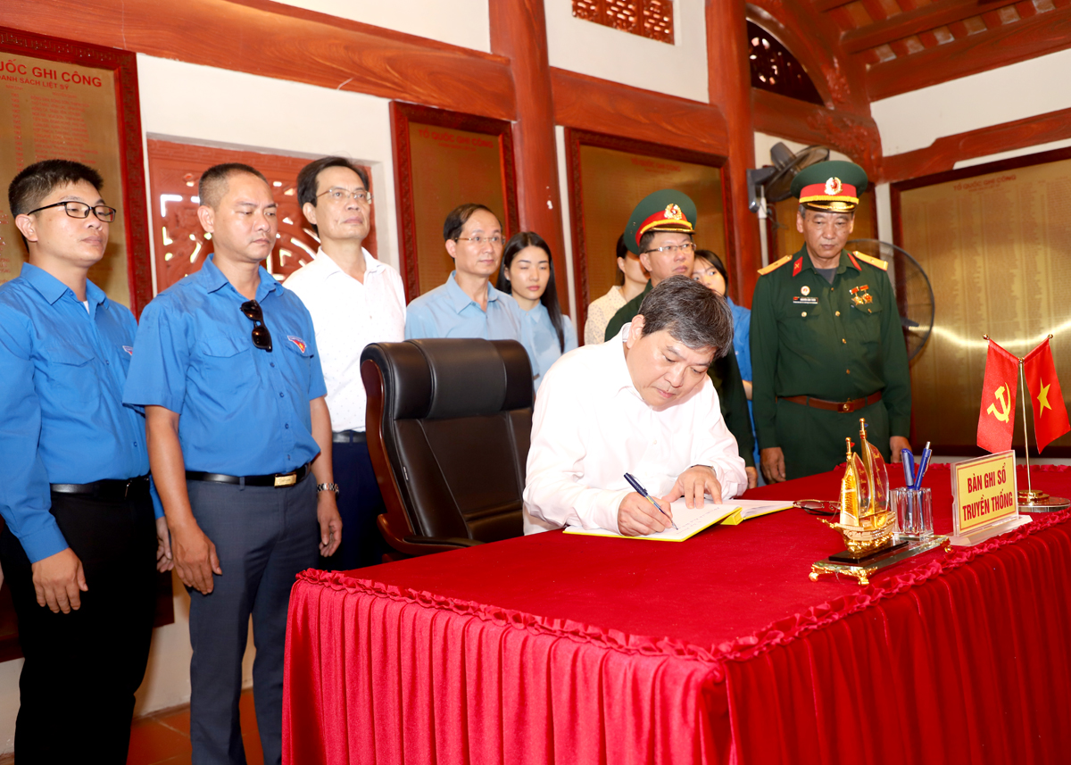 Phó Giám đốc Thường trực Học viện Chính trị Quốc gia Hồ Chí Minh Nguyễn Duy Bắc ghi lưu bút vào sổ truyền thống tại Nghĩa trang Liệt sỹ Quốc gia Vị Xuyên