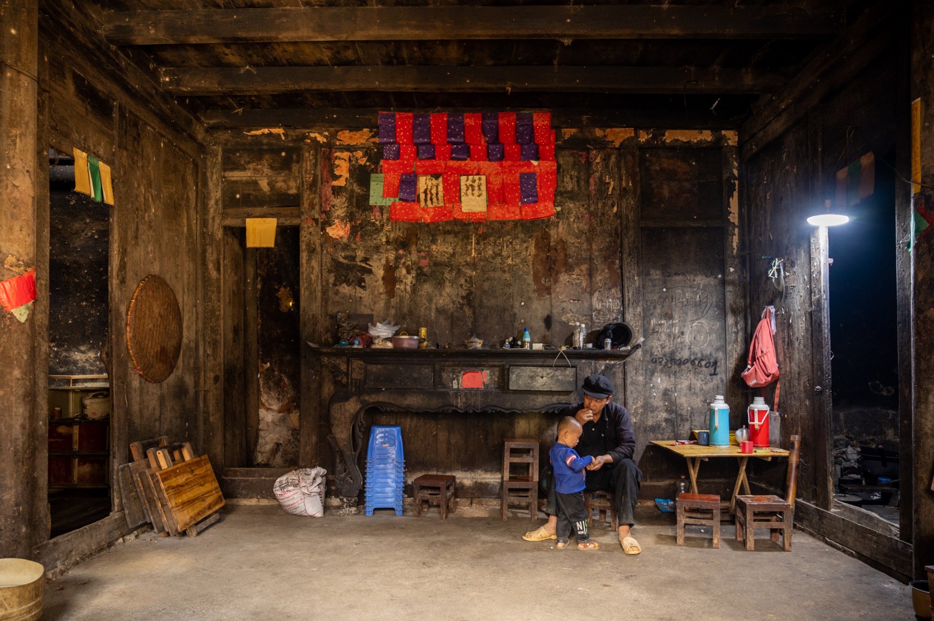 The guest reception room in the centre of the house contains an ancestral altar, with table legs shaped like goat hooves, dark black, and filled with accumulated dust.