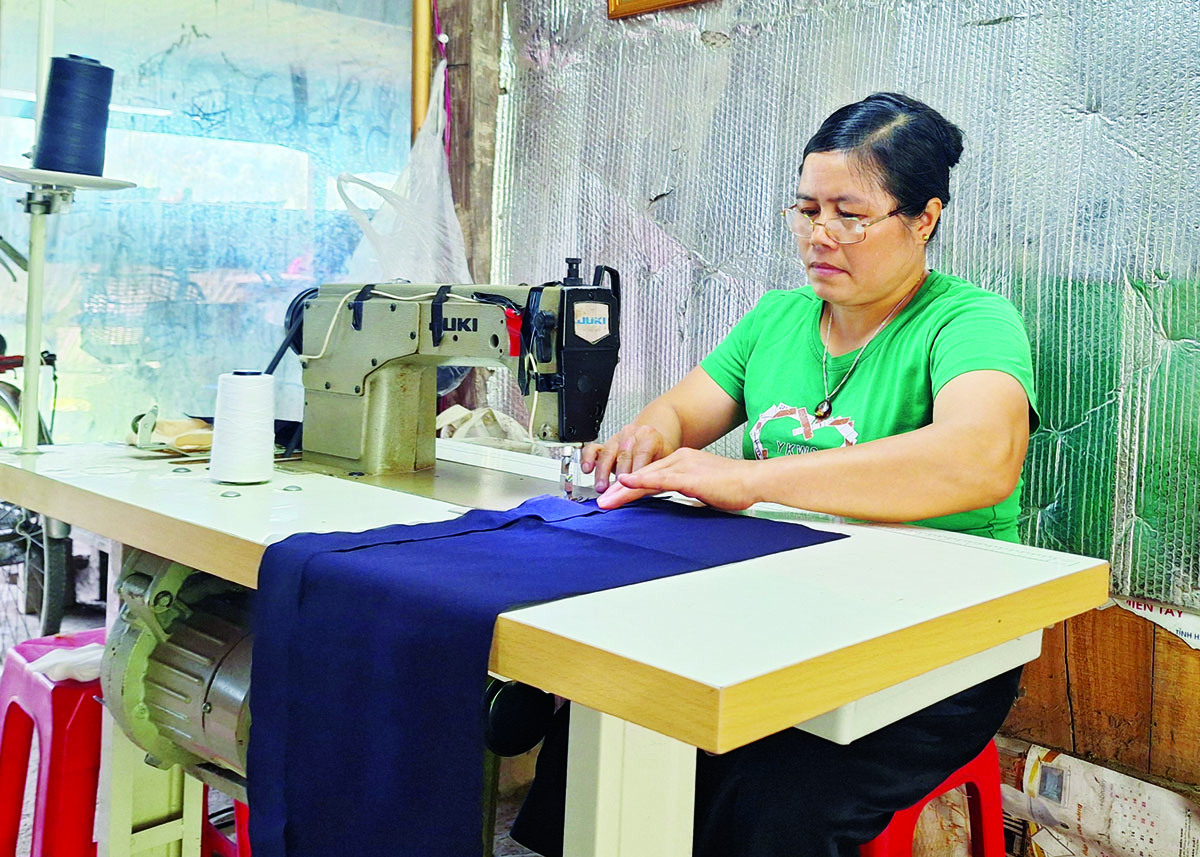 Nguyen Thi Dung works on a set of traditional Tay ethnic costumes.