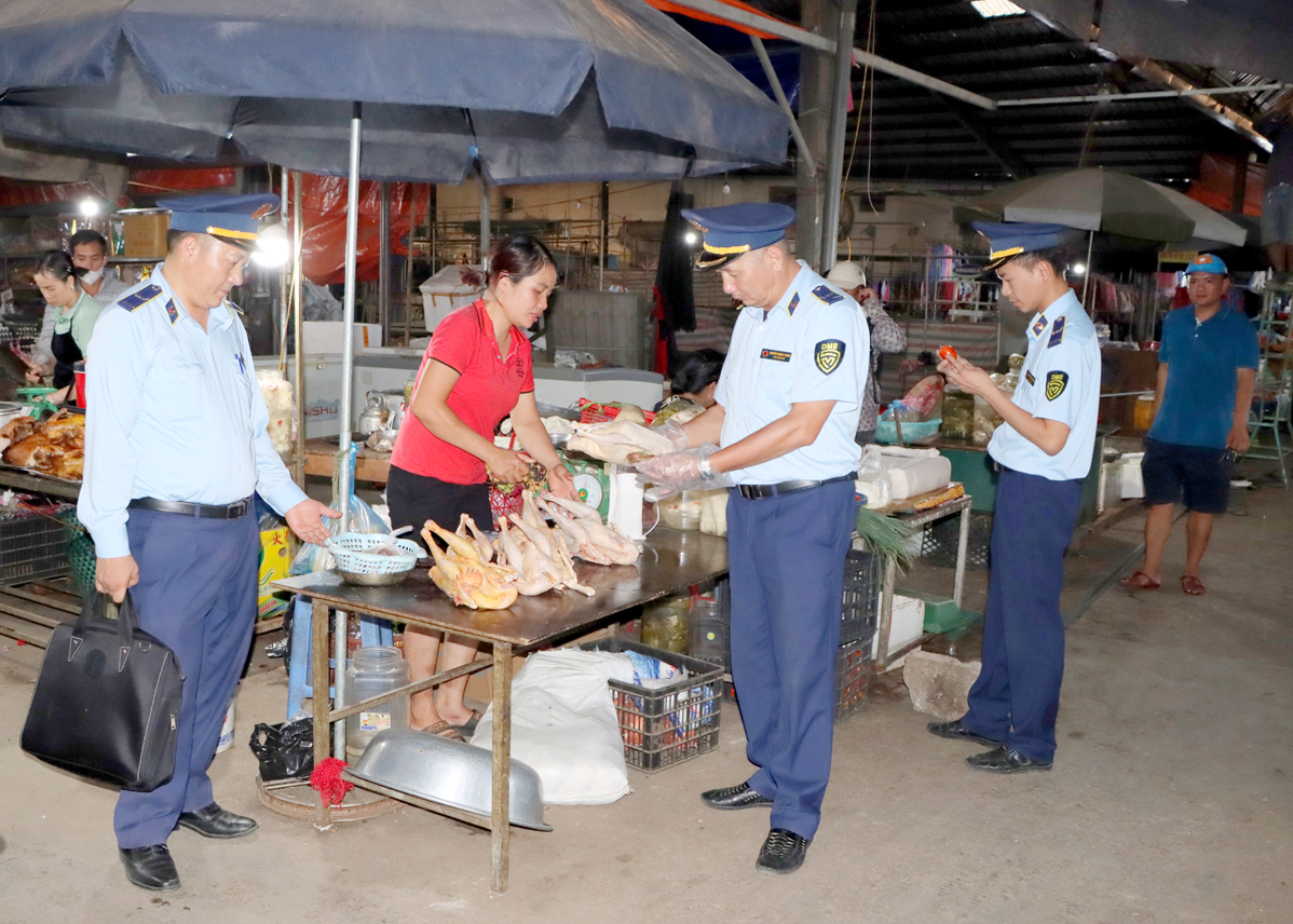 Cán bộ Đội Quản lý thị trường số 6 kiểm tra thực phẩm tươi sống tại chợ trung tâm huyện Mèo Vạc.