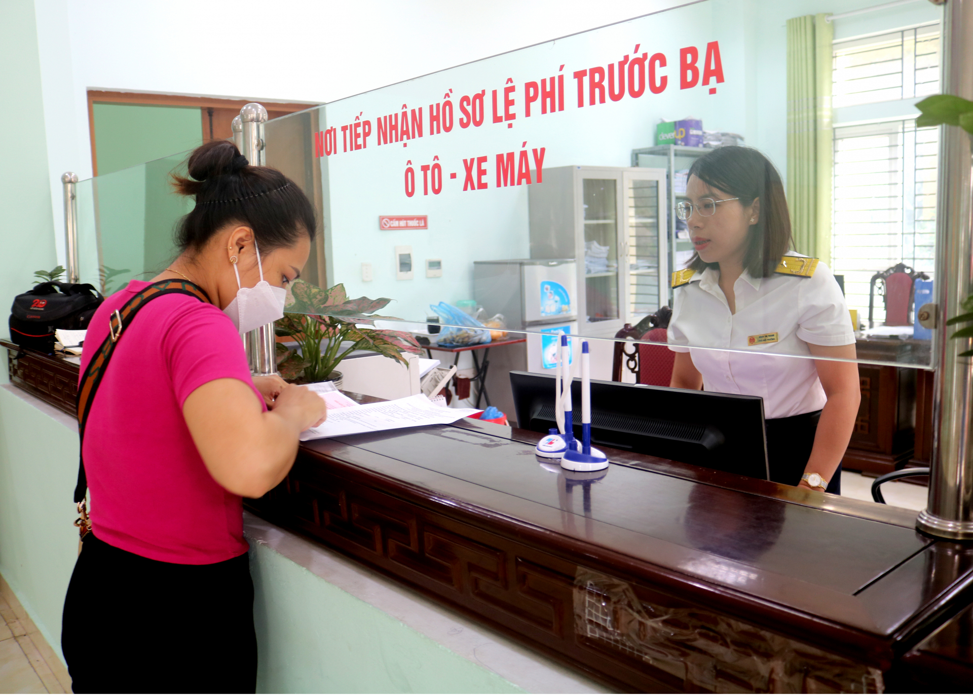 Cán bộ Chi cục Thuế thành phố Hà Giang hướng dẫn người dân làm thủ tục nộp thuế trước bạ xe máy.