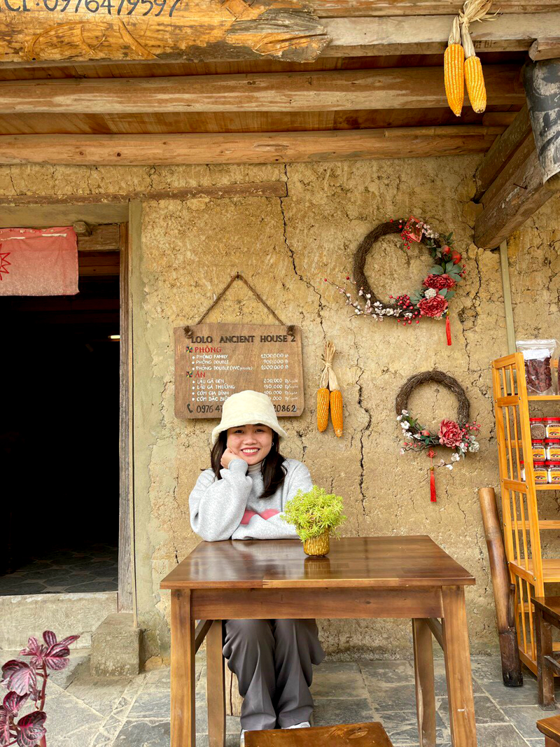 Tourists enjoy taking photos with the Homtay earthen house in the Ha Giang Karst Plateau.