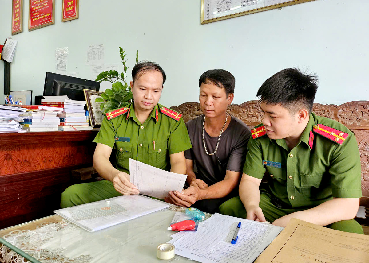 Đại úy Nguyễn Ngọc Hiếu (đầu tiên bên trái) hướng dẫn người dân làm thủ tục cấp thẻ Căn cước