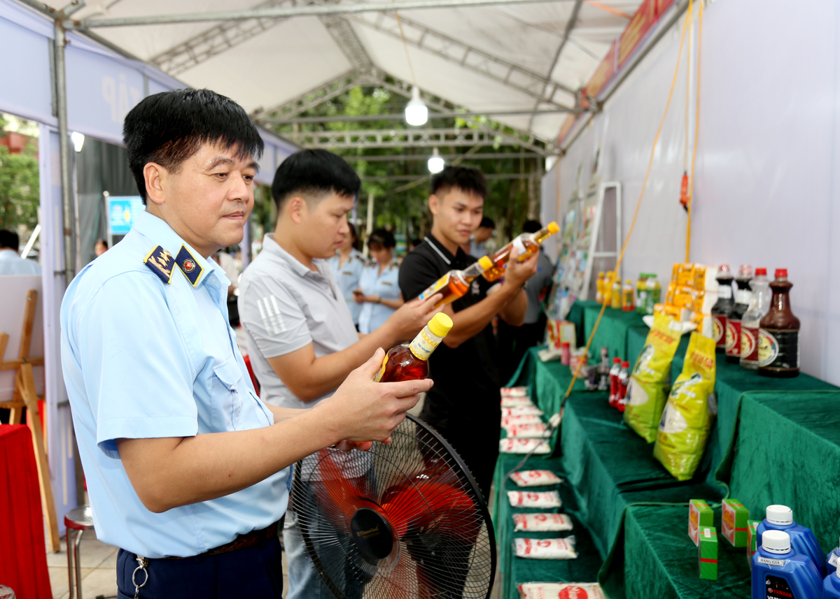 Cục trưởng Cục QLTT tỉnh Vũ Quốc Khánh kiểm tra các sản phẩm trưng bày tại gian hàng.