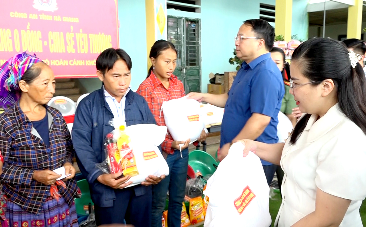 Đại tá Phan Huy Ngọc và lãnh đạo huyện Xín Mần tặng quà cho các hộ nghèo tại “Gian hàng 0 đồng - Chia sẻ yêu thương” ở xã Pà Vầy Sủ.