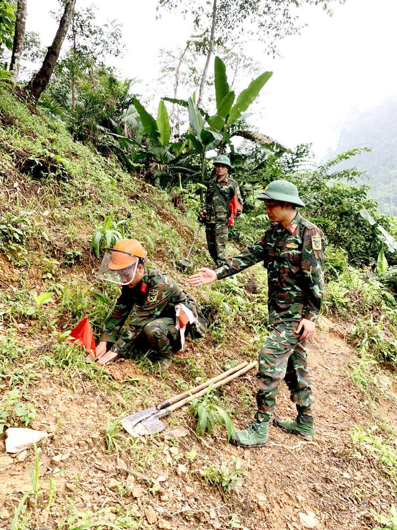 Thiếu tá BùI Anh Lâm, Phó đội trưởng Đội rà phá bom mìn Bộ CHQS tỉnh, quê xã Đồng Trung, huyện Thanh Thủy (Phú Thọ) hướng dẫn chiến sỹ làm nhiệm vụ. 				                         Ảnh: QUỲNH HƯƠNG