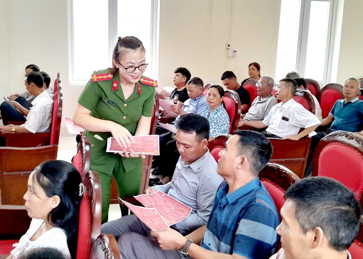 Cán bộ Công an xã Ngọc Đường (thành phố Hà Giang) phát tờ rơi, hướng dẫn người dân cài đặt định danh điện tử.
