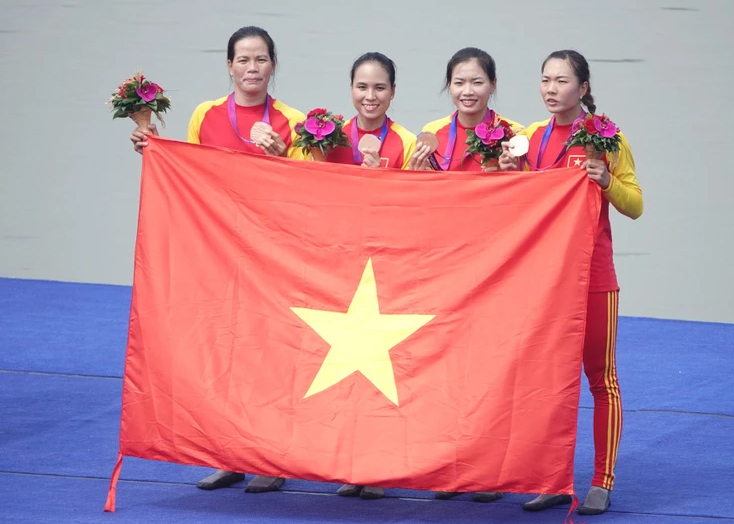 Các nữ vận động viên đội tuyển đua thuyền trên bục vinh quang. 