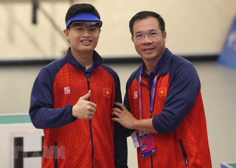 Xạ thủ Phạm Quang Huy (trái) và Huấn luyện viên Hoàng Xuân Vinh ăn mừng chiến thắng. 