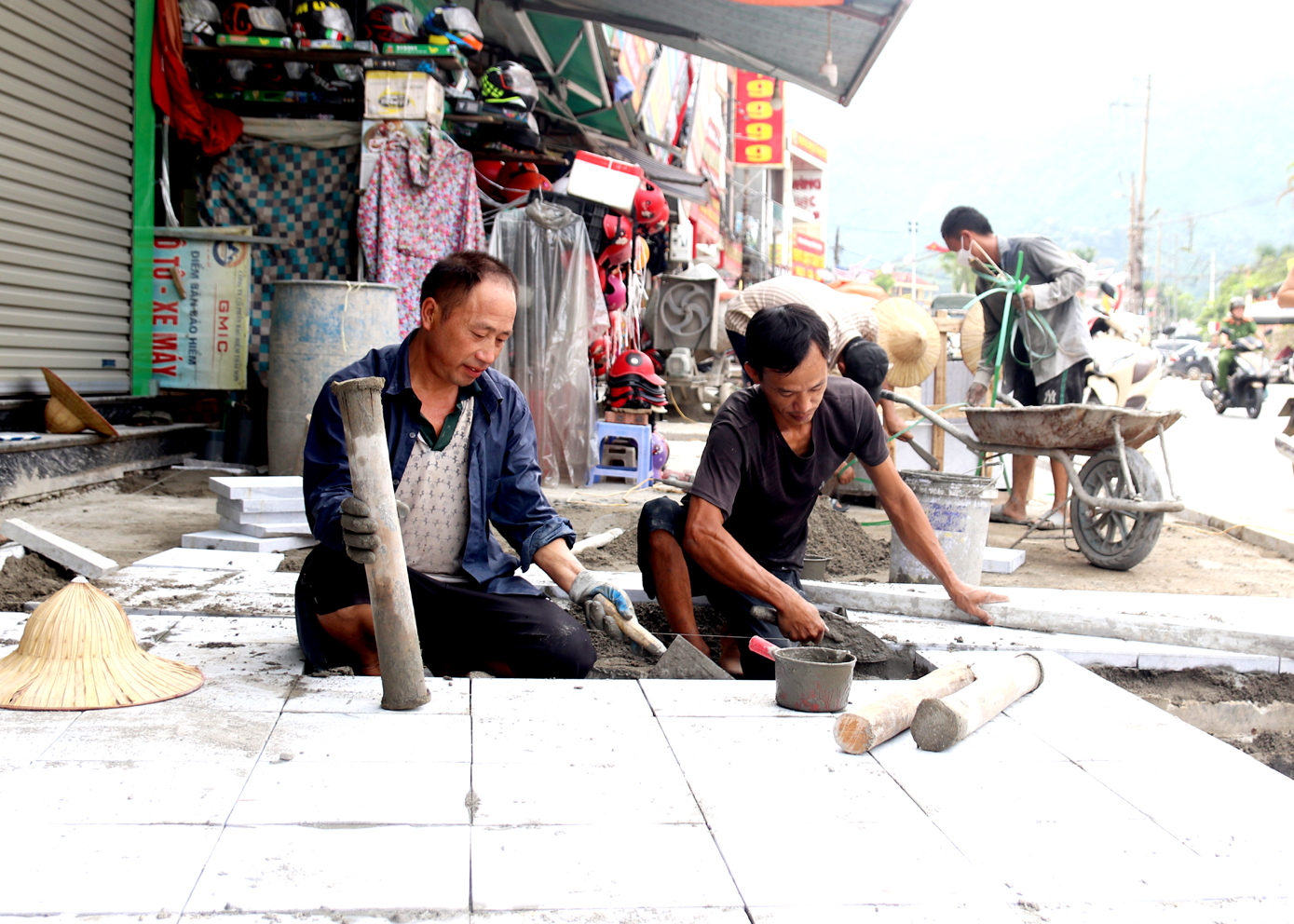 Nhân dân thị trấn Việt Quang (Bắc Quang) tham gia lát đá vỉa hè, chỉnh trang đô thị.
