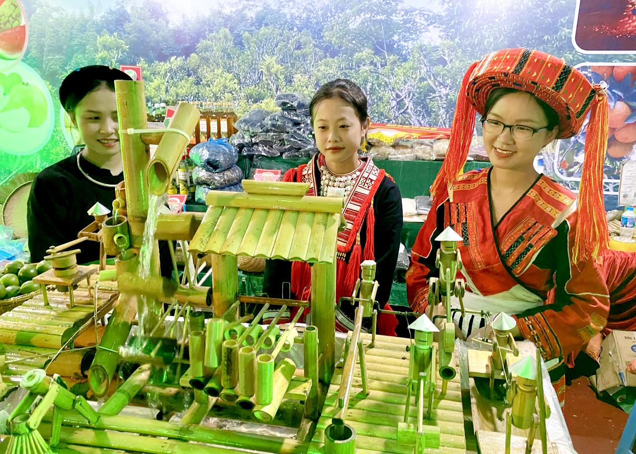 Thiếu nữ các dân tộc huyện Quang Bình bên mô hình đời sống sản xuất nông nghiệp làm từ nguyên liệu tre.