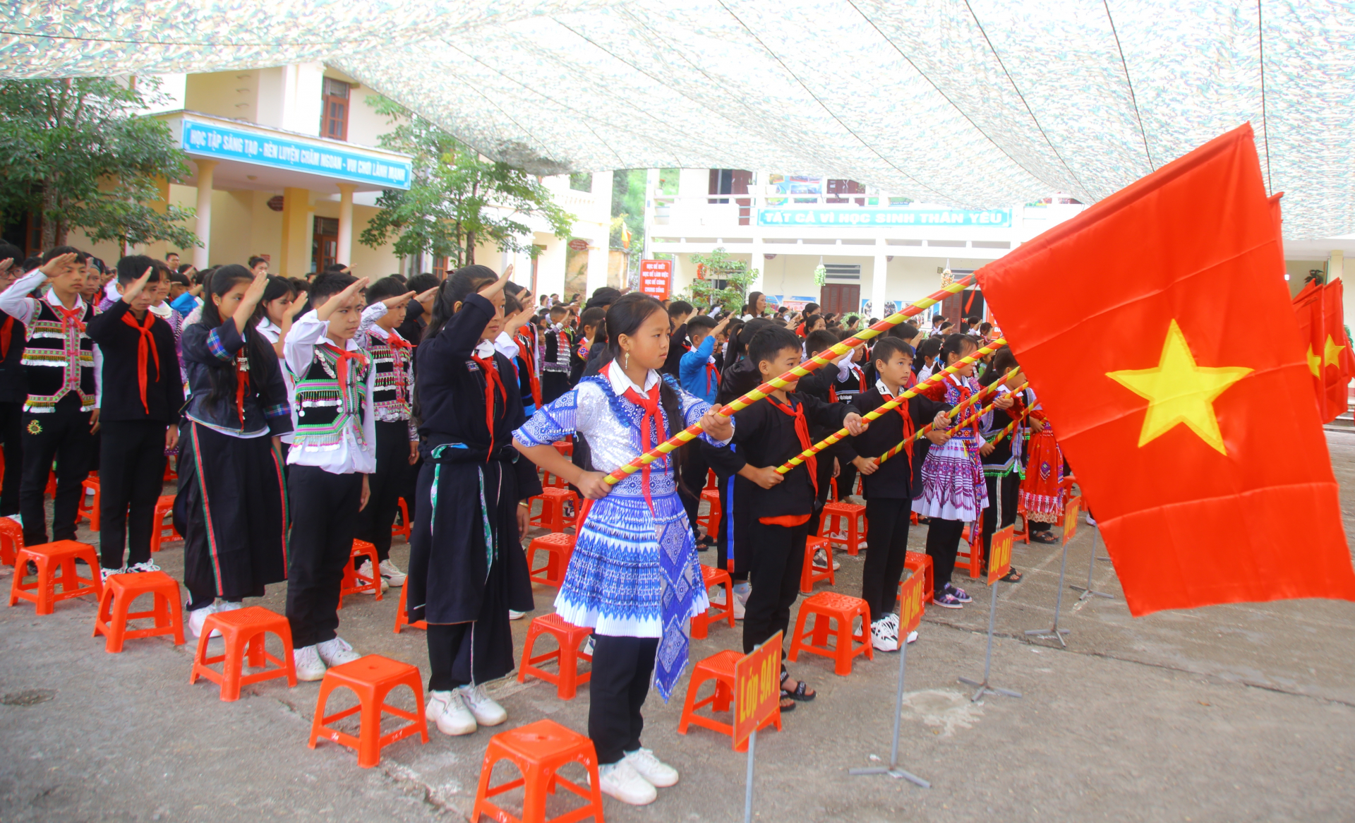 Học sinh liên trường Tiểu học và Phổ thông dân tộc nội trú xã biên giới Xín Mần thực hiện nghi lễ chào cờ trong lễ khai giảng năm học mới. Ảnh: Văn Long