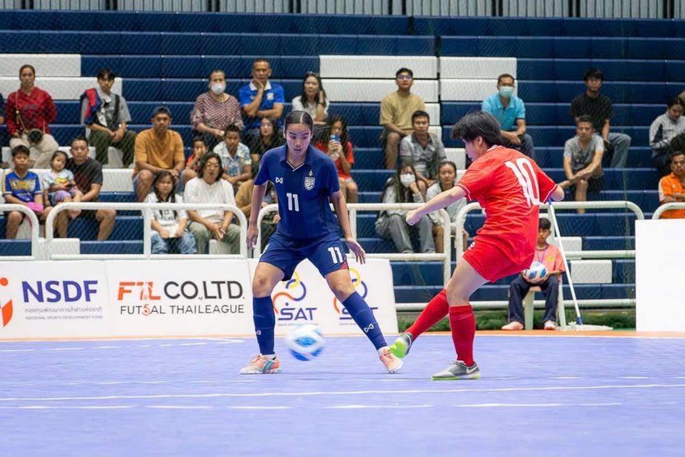 Tuyển futsal nữ Việt Nam thi đấu nỗ lực và cầm hòa đội chủ nhà Thái Lan (áo xanh) giành ngôi vô địch.