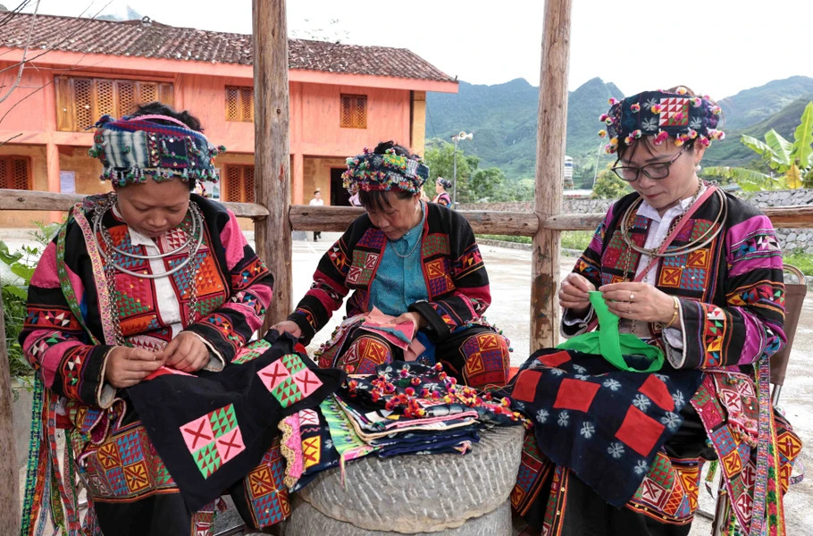 Lo Lo women skillfully embroider floral patterns on traditonal attire.