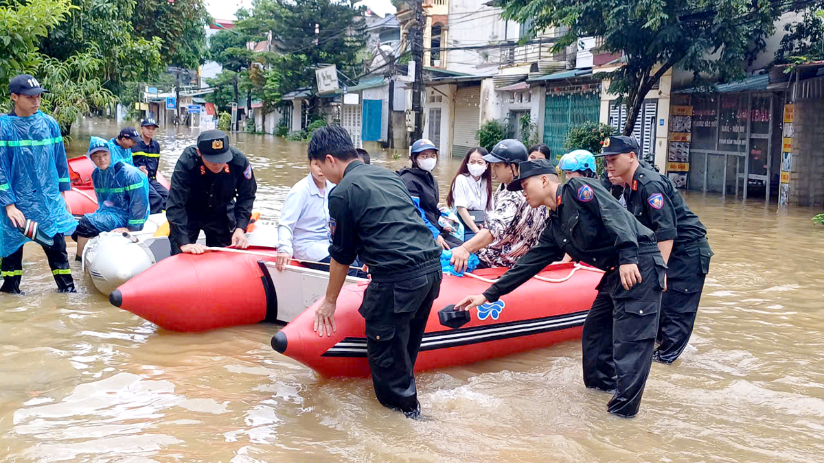 Cán bộ, chiến sỹ Công an tỉnh hỗ trợ người dân di chuyển tại khu vực ngập lụt tổ 2, phường Minh Khai, thành phố Hà Giang (ảnh chụp sáng 9.9). Ảnh: Mộc Lan