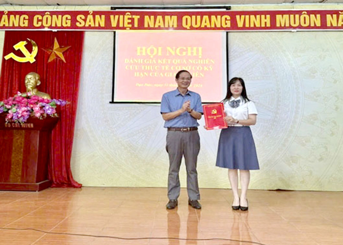 Đồng chí Phạm Sỹ Hùng, Hiệu trưởng trường Chính trị tỉnh Hà Giang trao quyết định hoàn thành đi nghiên cứu thực tế có kỳ hạn tại cơ sở cho đồng chí Đặng Ngọc Mai, Phó trưởng khoa Lý luận cơ sở