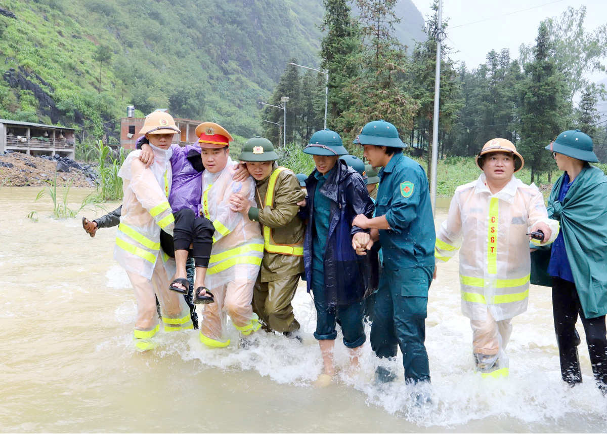 Lực lượng “4 tại chỗ” huyện Mèo Vạc vượt lũ đưa 1 bệnh nhân xuất huyết dạ dày đến bệnh viện cấp cứu kịp thời (ảnh chụp sáng 9.9). Ảnh: Minh Đức