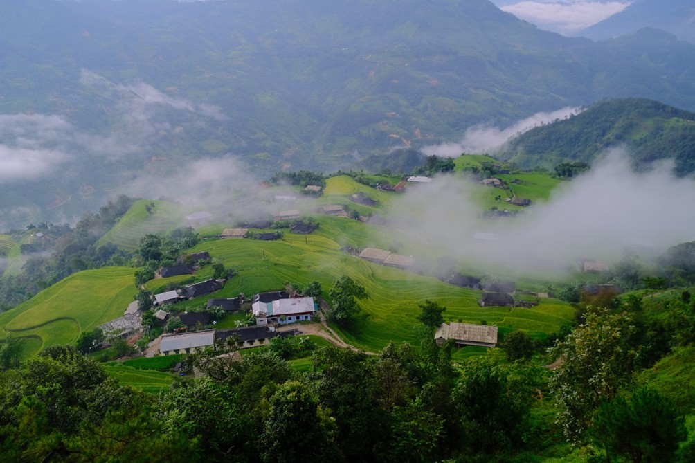 Những làn khói lam chiều phủ mờ trên những ngôi nhà nhỏ xa xa, tạo nên khung cảnh yên bình và có chút cô liêu.