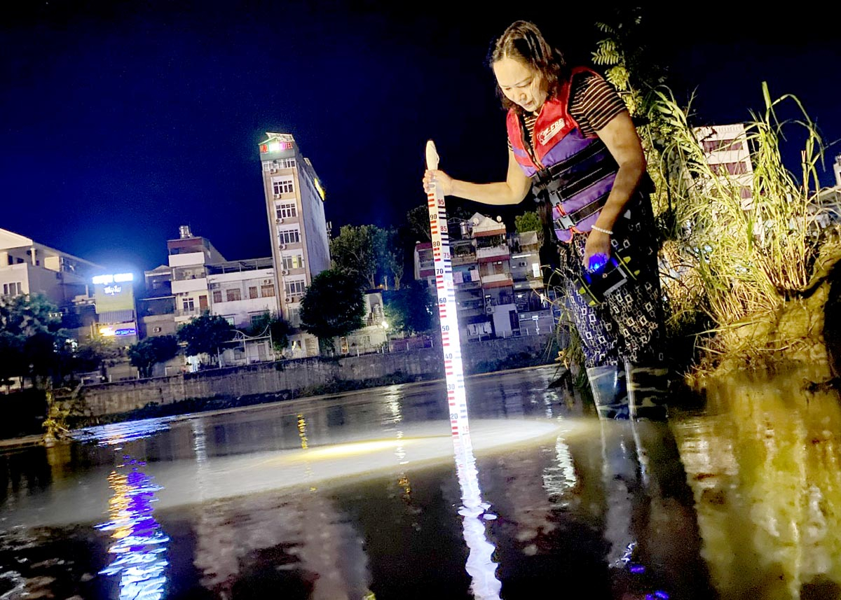 Ha Giang Hydrometeorological Station observers measure the water level of the Lo River during the night shift.