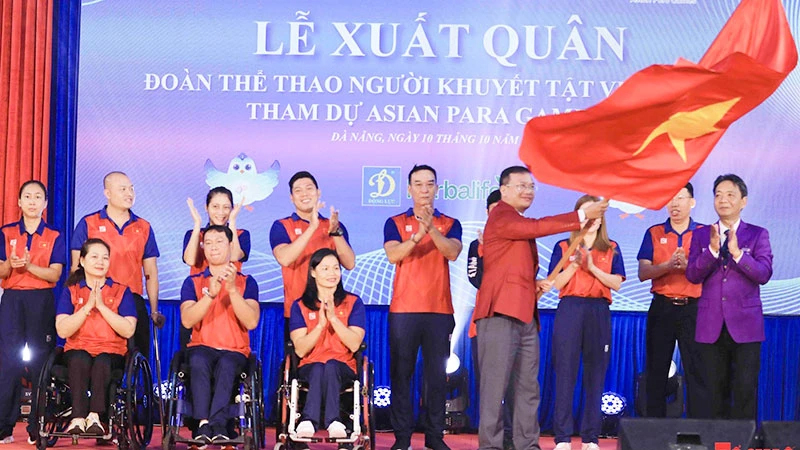 Lãnh đạo và đại diện các đội tuyển Đoàn thể thao người khuyết tật Việt Nam nhận cờ tại lễ xuất quân dự ASIAN Para Games 4. 