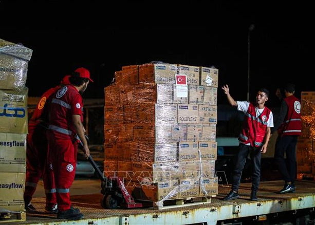 Nhân viên Hiệp hội Trăng lưỡi liềm đỏ Ai Cập vận chuyển hàng viện trợ cho Gaza tại nhà kho ở al-Arish (Ai Cập) ngày 23/10/2023.