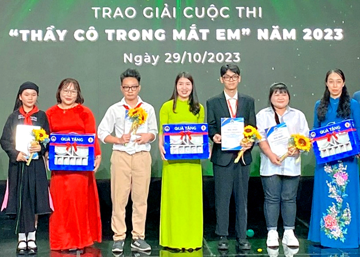 Học sinh Ly Thị Ánh và giáo viên chủ nhiệm (đầu tiên bên trái) Trường Phổ thông dân tộc Nội trú THCS&THPT Hoàng Su Phì nhận giải Nhất. (Ảnh: CTV) (cúp 2 ông đứng hai bên)