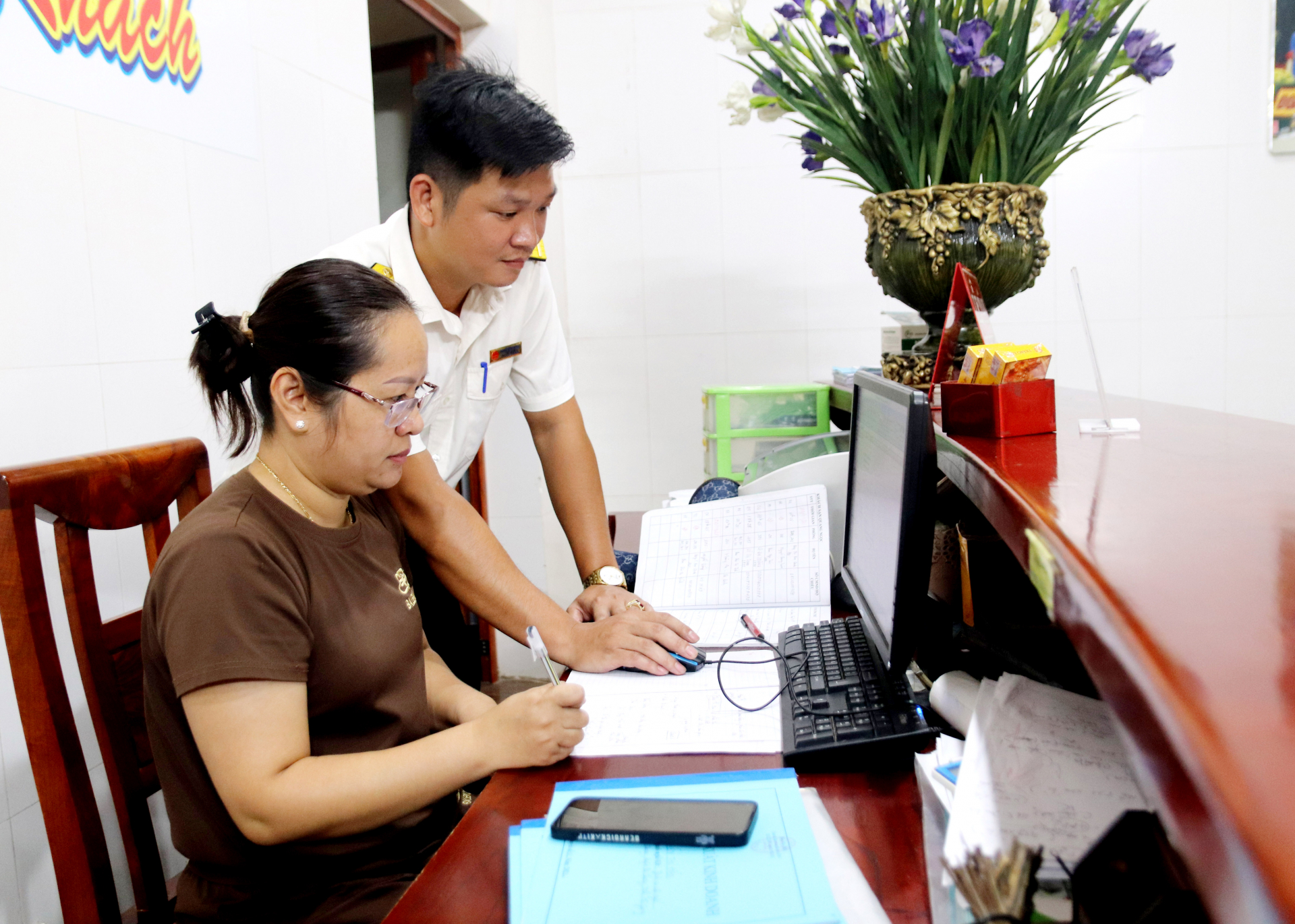 Cán bộ Chi cục Thuế khu vực Bắc Quang – Quang Bình kiểm tra sổ sách đối với hộ kinh doanh nộp thuế theo phương pháp kê khai.