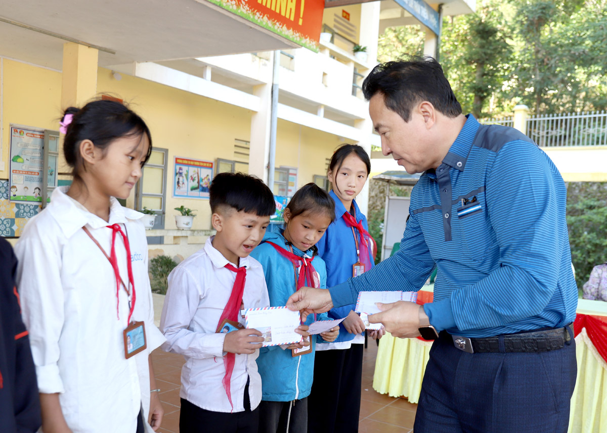 Đồng chí Nguyễn Bình Minh, Phó Tổng Biên tập Báo Hà Giang tặng quà các em học sinh trường PTDT BT THCS Tả Lủng (Mèo Vạc)