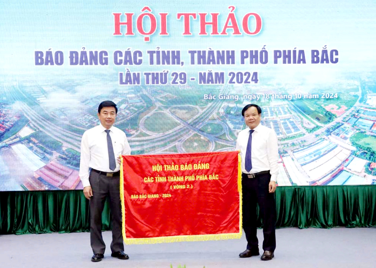 Đồng chí Trịnh Văn Ánh, Tổng Biên tập Báo Bắc Giang trao Cờ đăng cai Hội thảo lần thứ 30 cho Báo Hà Nội Mới.