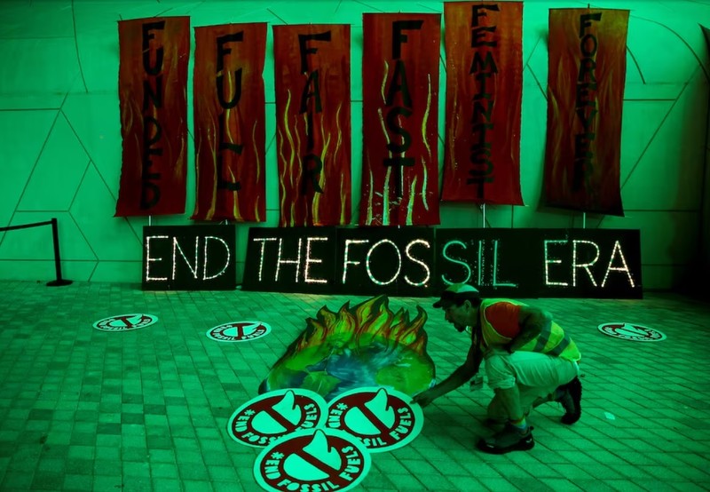 A climate activist arranges artwork against fossil fuels at Dubais Expo City during the United Nations Climate Change Conference COP28 in Dubai, United Arab Emirates, December 12, 2023.