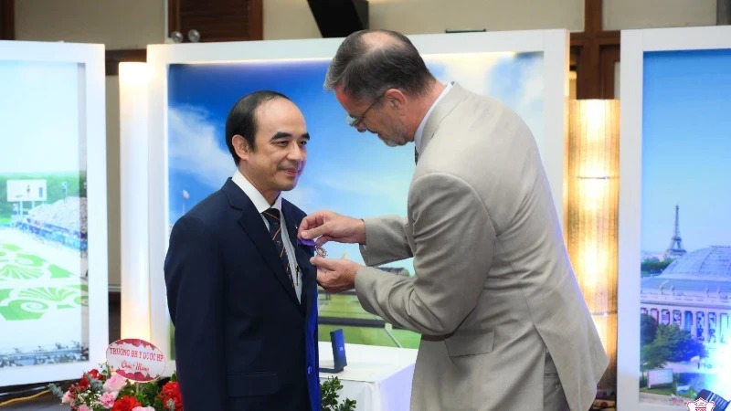 French Ambassador to Vietnam, Olivier Brochet, presents the Order of Academic Palms to Professor Dr Nguyen Huu Tu