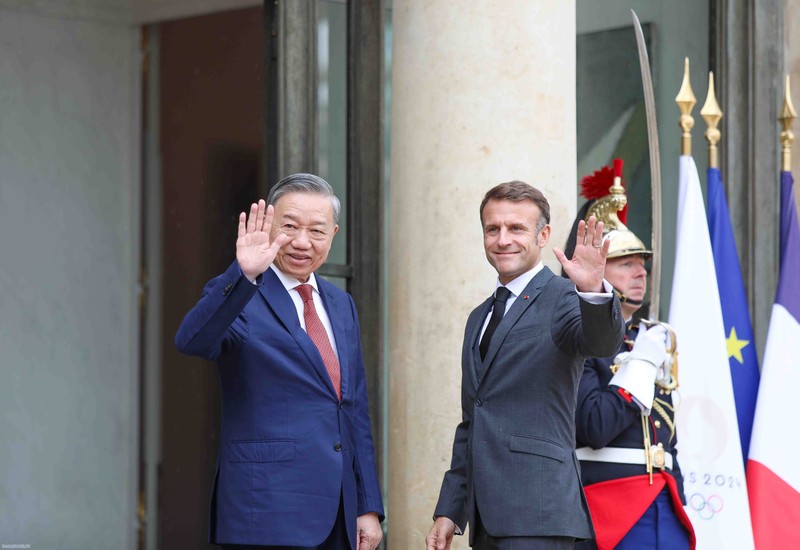 French President Emmanuel Macron (R) and Vietnamese Party General Secretary and State President To Lam