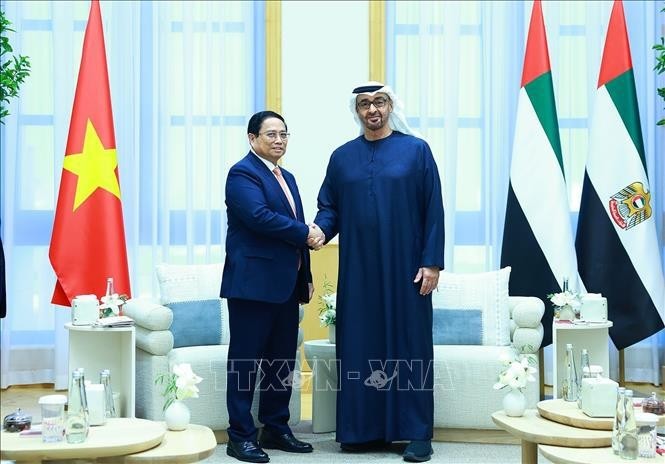 Prime Minister Pham Minh Chinh (L) shakes hands with President of the UAE Mohamed bin Zayed Al Nahyan.