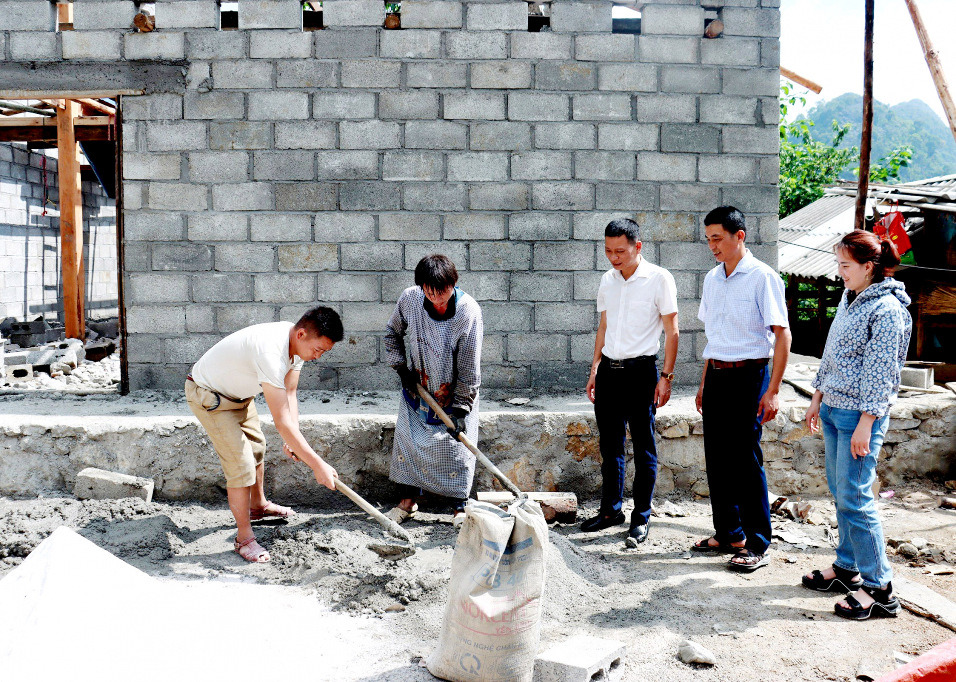 Cán bộ xã Lũng Pù (Mèo Vạc) kiểm tra tiến độ xây dựng nhà ở cho hộ nghèo từ nguồn vốn Chương trình mục tiêu quốc gia giảm nghèo bền vững. 							Ảnh: Trần Kế