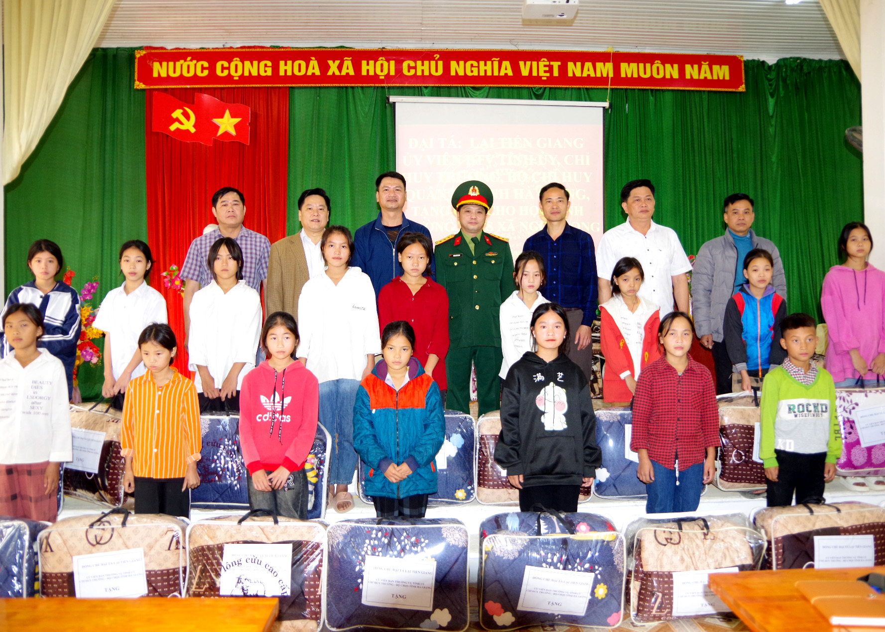 Đại diện lãnh đạo Bộ CHQS tỉnh trao chăn ấm cho học sinh Trường THCS xã Ngọc Long, huyện Yên Minh.