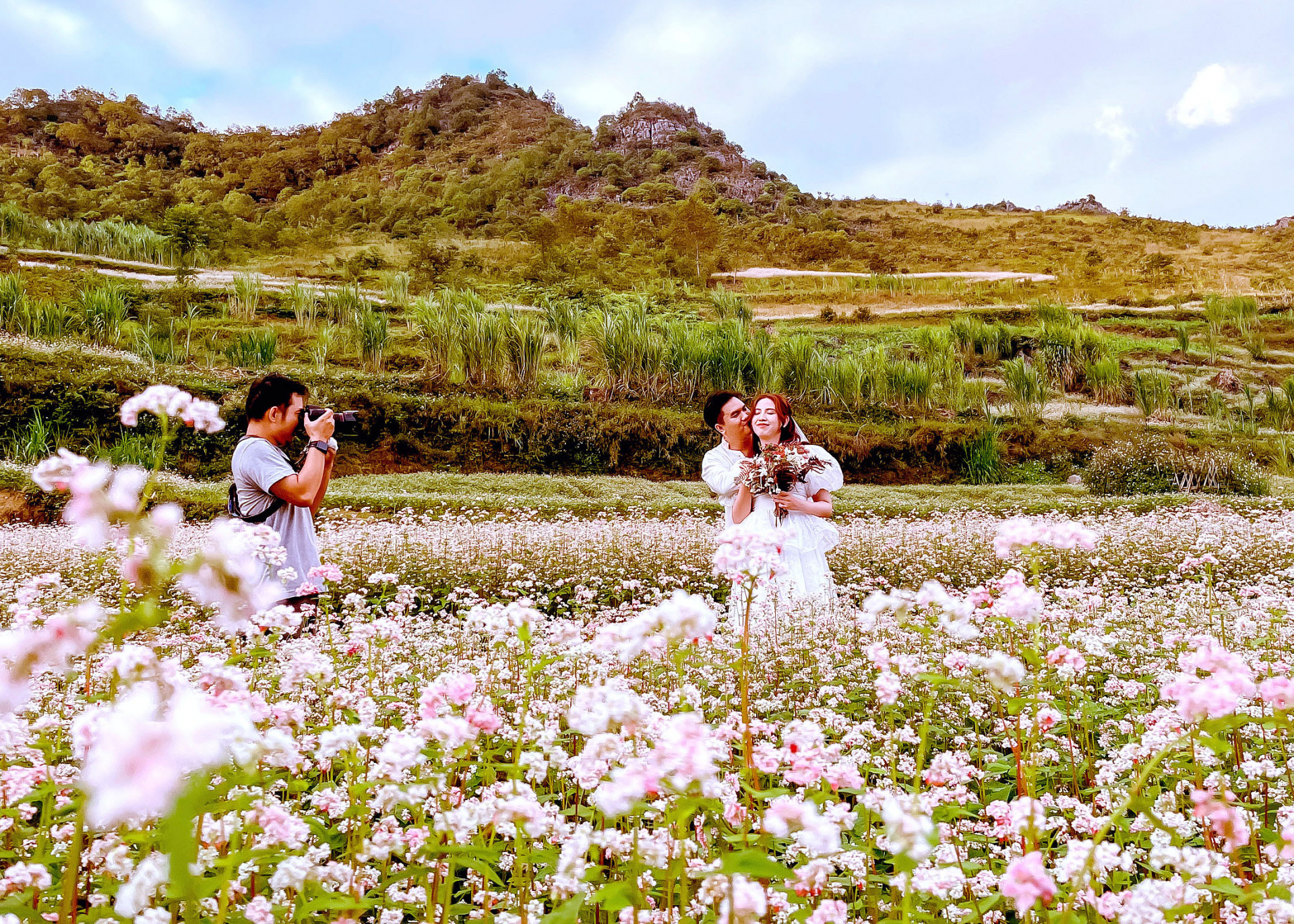Nhiếp ảnh gia Phạm Hưởng đang ghi dấu ấn hạnh phúc một cặp đôi đến từ Thành phố Hồ Chí Minh trên cánh đồng hoa Tam giác mạch.