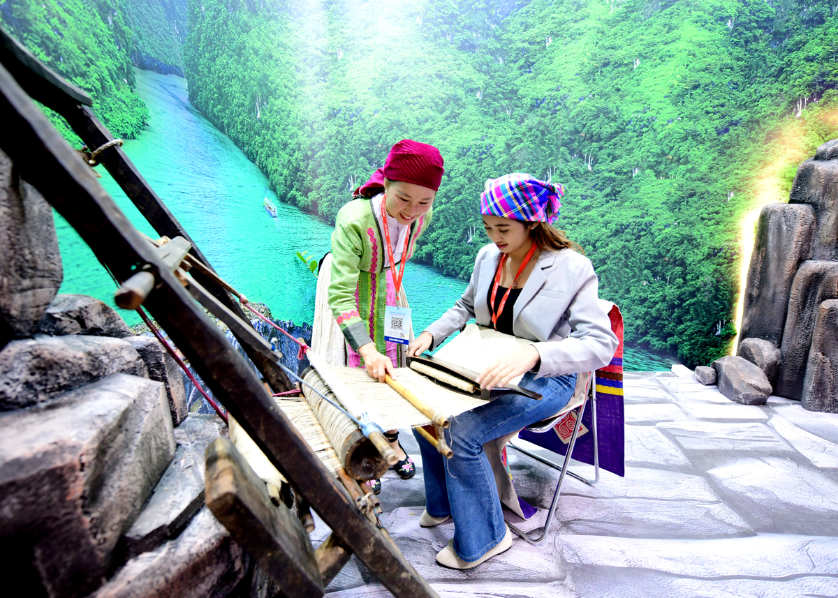 Vang Thi De introduces tourists to linen weaving at the Ho Chi Minh City International Travel Expo.