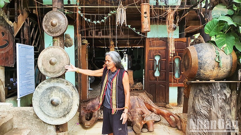 A Biu enthusiastically introduces his gong collection to tourists.