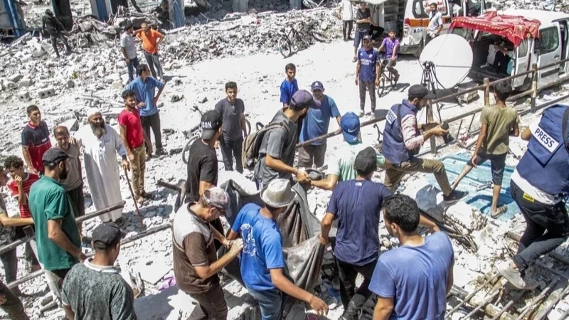 People search for victims under the rubble of a school destroyed after an Israeli airstrike on the Gaza Strip on August 20, 2024. 