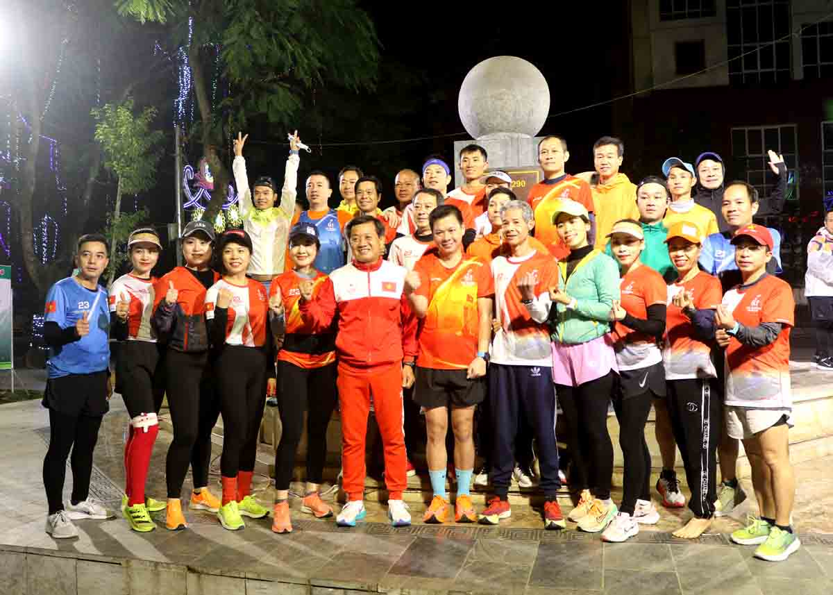 Ông Đoàn Ngọc Hải chụp ảnh lưu niệm với các thành viên CLB Hà Giang Runner tại cột mốc số Km0 trước khi xuất phát giải chạy Chào năm mới 2024.