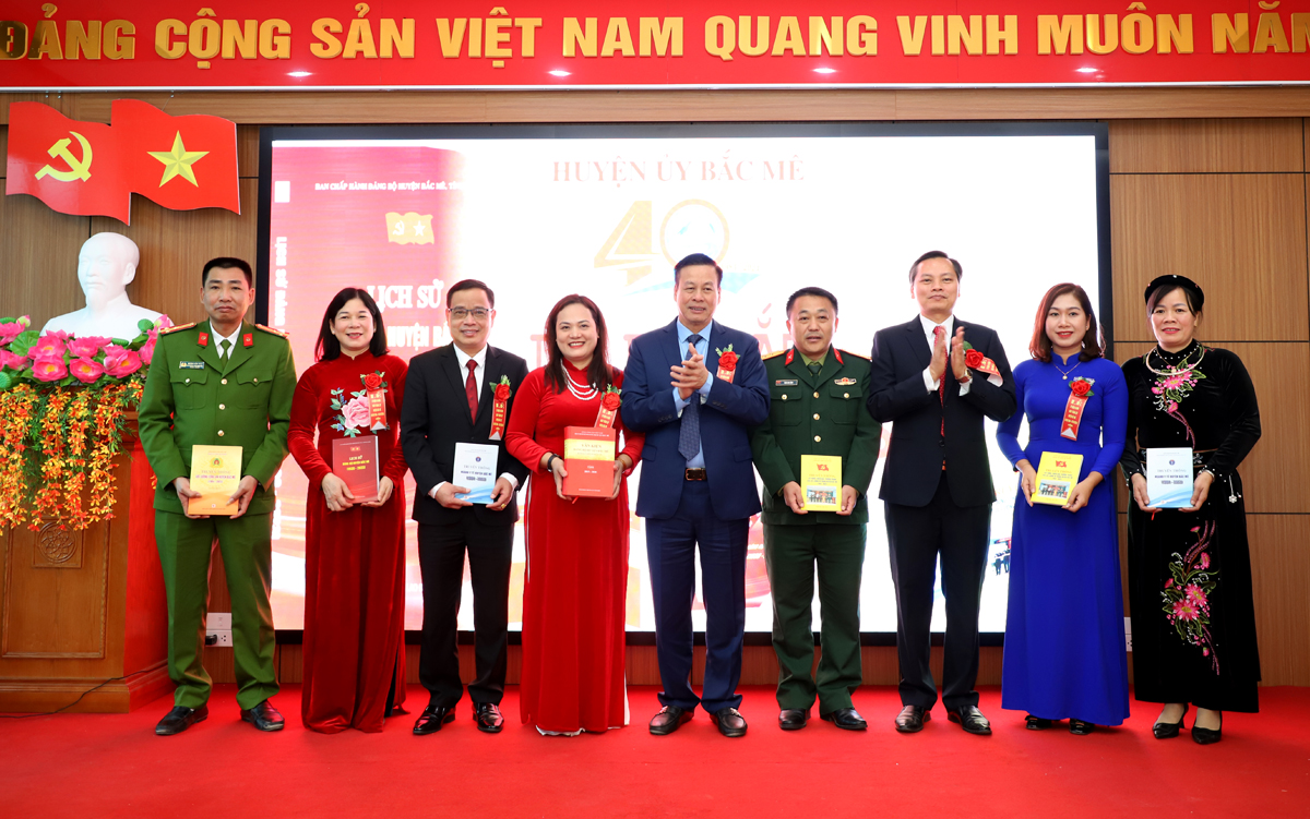 Chủ tịch UBND tỉnh Nguyễn Văn Sơn và Phó Chủ tịch Thường trực HĐND tỉnh Chúng Thị Chiên trao các cuốn sách lịch sử cho đại diện các đơn vị.