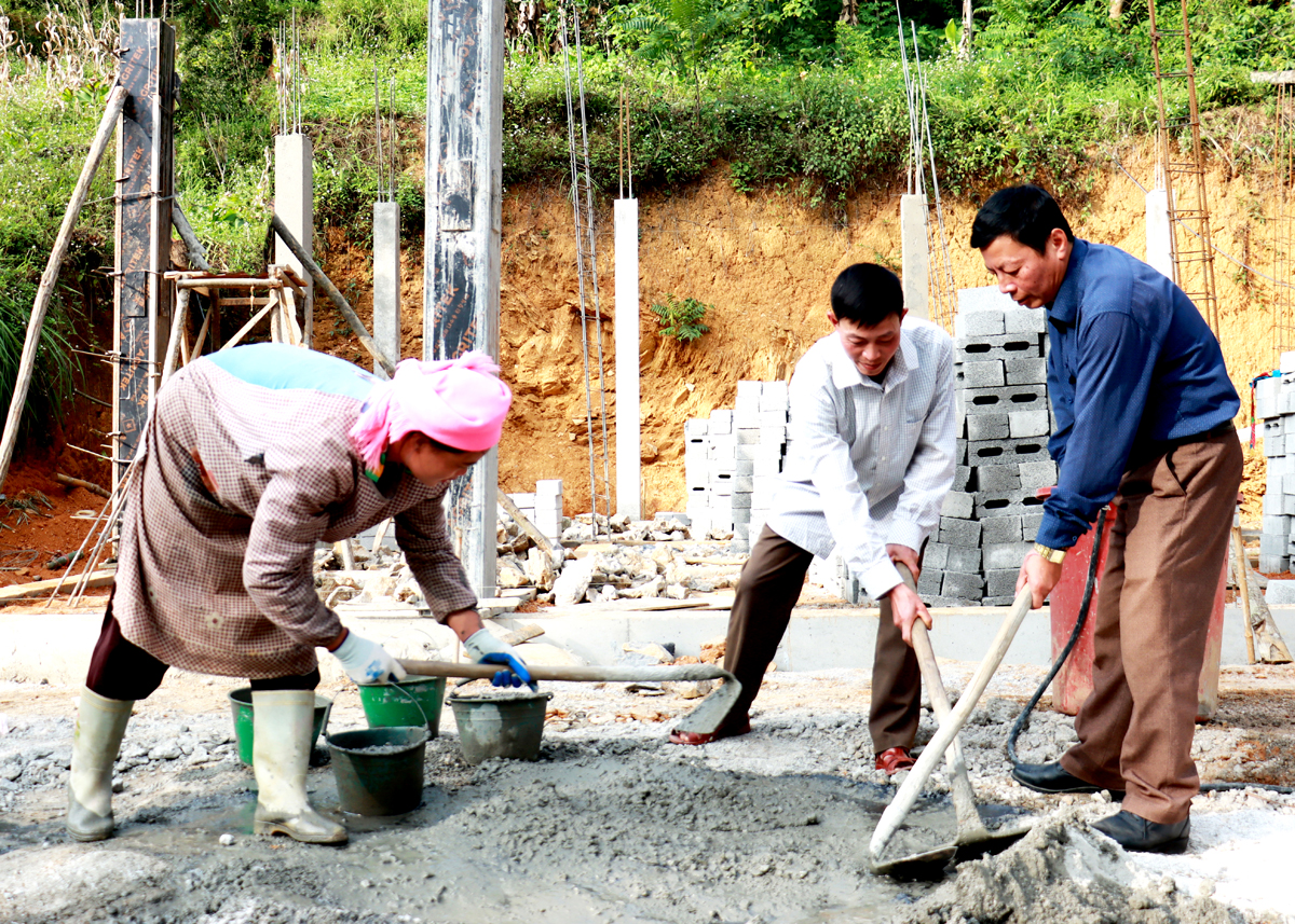 Cán bộ, đảng viên xã Xín Cái (Mèo Vạc) giúp hộ nghèo xây dựng nhà ở.