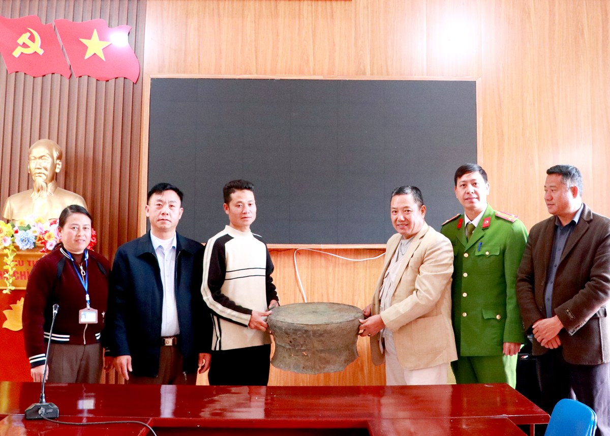 A representative of the Lung Cu Commune authorities hands over the bronze drum to the Provincial Museum.