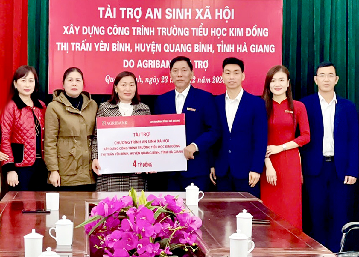 Đồng chí Vũ Bá Bống, Giám đốc Agribank huyện Quang Bình trao kinh phí an sinh xã hội do Agribank tài trợ cho UBND huyện Quang Bình