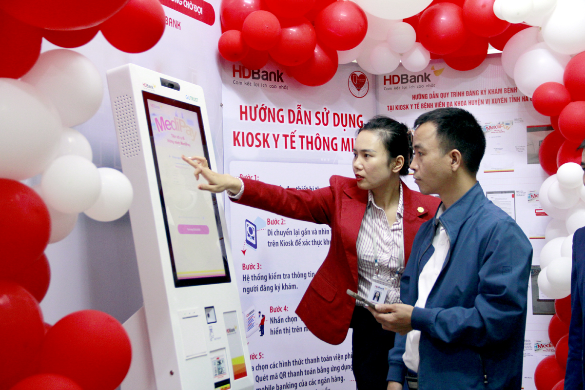 Cán bộ HDBank hướng dẫn người dân sử dụng Kiosk y tế thông minh.