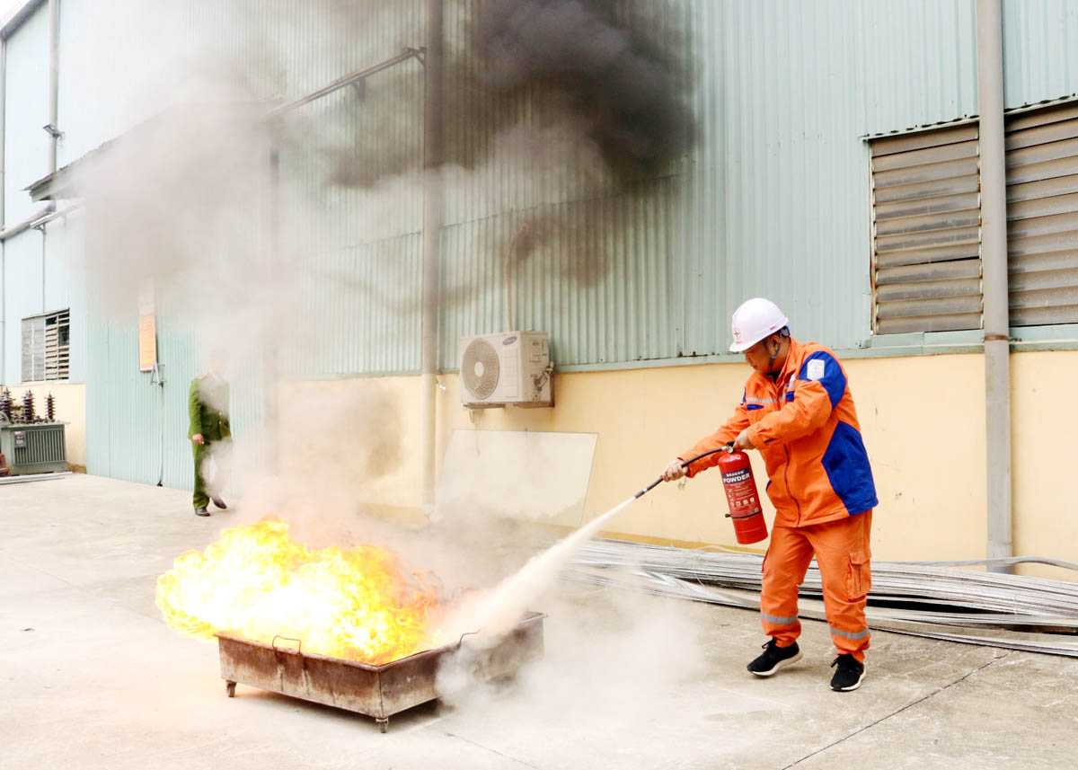 Cán bộ, người lao động Công ty Điện lực Hà Giang tham gia thực hành dập tắt đám cháy tại khay xăng.