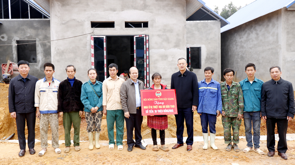 Chủ tịch Hội Nông dân tỉnh Hoàng Văn Thịnh và lãnh đạo huyện Quang Bình trao kinh phí hỗ trợ của Hội Nông dân tỉnh Hậu Giang cho các hộ dân khu tái định cư thôn Yên Lập.