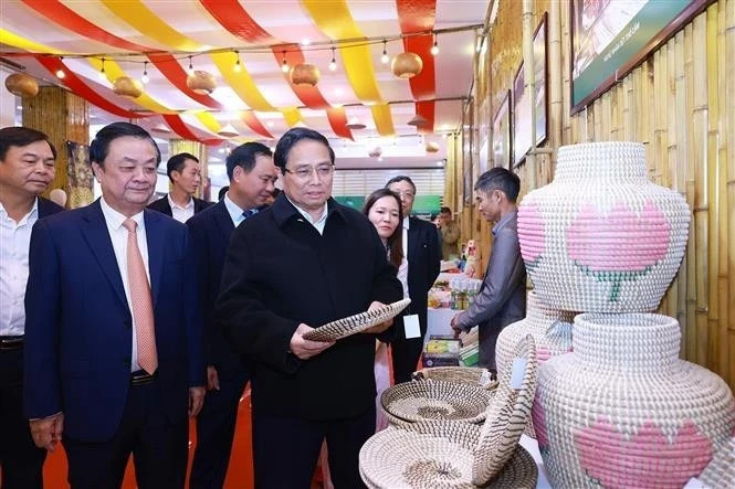 Prime Minister Pham Minh Chinh visits a booth displaying handicraft and fine arts products.